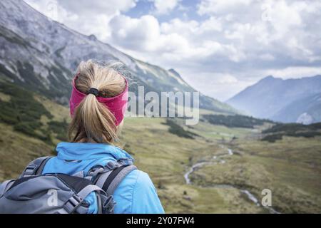 Donna in abbigliamento sportivo e con zaino si gode della vista sulle montagne Foto Stock