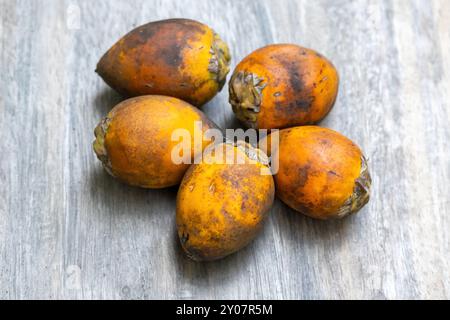 Noce di betel fresco maturo o Areca catechu su fondo di legno. Foto Stock