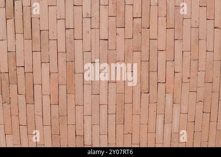 Un muro di mattoni con un motivo di quadrati. Il muro è marrone e ha una consistenza ruvida. Il motivo è composto da quadrati di dimensioni diverse. Foto Stock