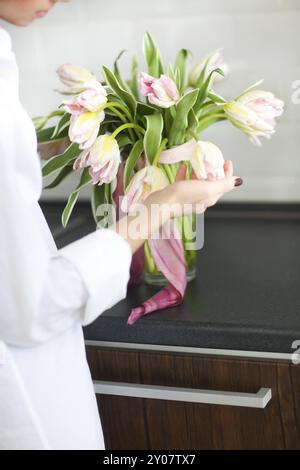 Donna disponendo bouquet floreale in una cucina. Close up Foto Stock