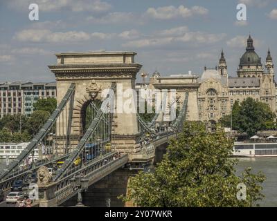 Vista del ponte sul fiume sullo sfondo dell'architettura urbana e del verde, budapest, danubio, ungheria Foto Stock