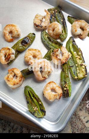 Una vista dall'alto verso il basso di gamberi arrostiti e peperoni jalapeno su una teglia da forno. Foto Stock