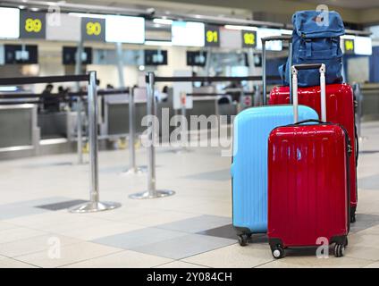 Pila di viaggiatori bagagli nel terminal dell'aeroporto al check in Foto Stock