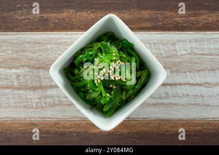 Vista dall'alto verso il basso di una tazza di condimento con insalata wakame. Foto Stock