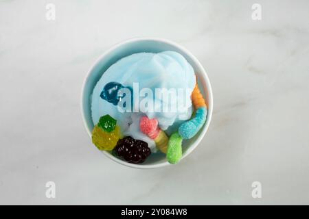 Vista dall'alto di una tazza di yogurt gelato al lampone blu con condimenti di caramelle. Foto Stock