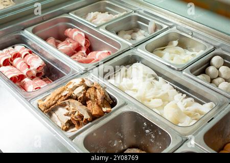 Vista su una tavola della vaporiera piena di ingredienti assortiti. Foto Stock