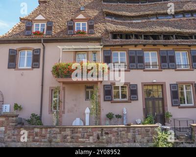 Storica casa in legno con balcone fiorito e giardino decorativo, Weissenburg, Alsazia, Francia, Europa Foto Stock