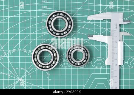 Misurare la pinza e i cuscinetti a rulli sul tappeto da taglio verde con spazio libero per copiare. Ingegneria meccanica e industria automobilistica Foto Stock