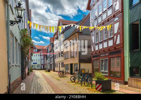 Strada tranquilla con case a graticcio e decorazioni festose a Marburgo, in Germania, in una giornata nuvolosa Foto Stock