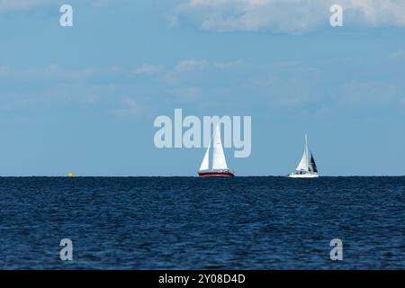 South Amboy, New Jersey - 21 agosto 2024: Le barche a vela navigano nella baia di Raritan durante le loro corse del mercoledì sera nell'estate del 2024 Foto Stock