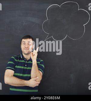 Giovane uomo che pensa. Disegno con gesso su sfondo scuro Foto Stock