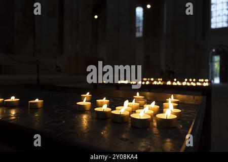 Incandescente candele in una chiesa Foto Stock