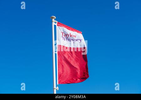 Norwich, Regno Unito - agosto 30 2024: Bandiera rossa o logo per costruttori di casa del Regno Unito, Taylor Wimpey Foto Stock