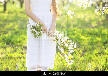Concetto di bellezza. In prossimità delle mani della donna oltre il giardino di primavera e la fioritura dei ciliegi sfondo Foto Stock