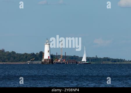 South Amboy, New Jersey - 21 agosto 2024: Le barche a vela navigano nella baia di Raritan durante le loro corse del mercoledì sera nell'estate del 2024 Foto Stock