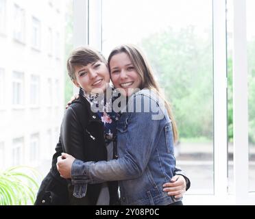 Due lieti studentesse vicino alla finestra in aula Foto Stock