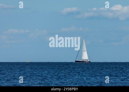 South Amboy, New Jersey - 21 agosto 2024: Le barche a vela navigano nella baia di Raritan durante le loro corse del mercoledì sera nell'estate del 2024 Foto Stock