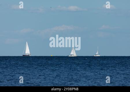 South Amboy, New Jersey - 21 agosto 2024: Le barche a vela navigano nella baia di Raritan durante le loro corse del mercoledì sera nell'estate del 2024 Foto Stock