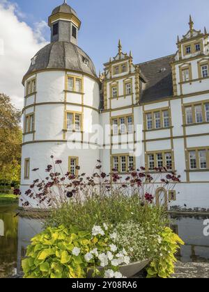 Castello barocco con torre e bellissimo giardino pieno di fiori sul bordo di un fossato, castello di Neuhaus, Germania, Europa Foto Stock