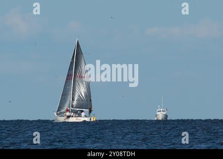 South Amboy, New Jersey - 21 agosto 2024: Le barche a vela navigano nella baia di Raritan durante le loro corse del mercoledì sera nell'estate del 2024 Foto Stock