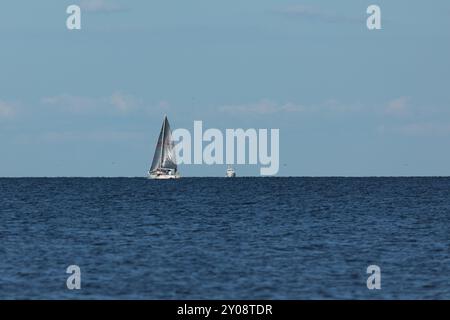 South Amboy, New Jersey - 21 agosto 2024: Le barche a vela navigano nella baia di Raritan durante le loro corse del mercoledì sera nell'estate del 2024 Foto Stock