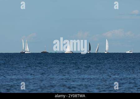 South Amboy, New Jersey - 21 agosto 2024: Le barche a vela navigano nella baia di Raritan durante le loro corse del mercoledì sera nell'estate del 2024 Foto Stock