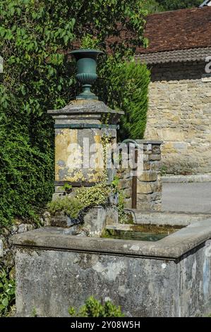 Vecchia fontana storica con rubinetto curvo beccuccio per l'acqua potabile permanente acqua potabile pulita per il consumo umano cibo con insegna Eau Foto Stock