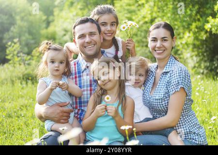 Felice famiglia giovane con quattro figli nella foresta di primavera Foto Stock