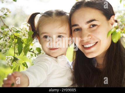 Felice sua madre e la sua piccola figlia nella giornata di primavera. Ritratto all'aperto Foto Stock