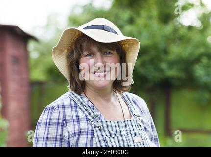 Donna di mezza età in cappello che lavora in giardino Foto Stock