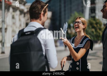 Gli uomini d'affari si incontrano all'aperto, discutendo strategie di marketing e crescita delle vendite in un ambiente urbano in una giornata di sole Foto Stock