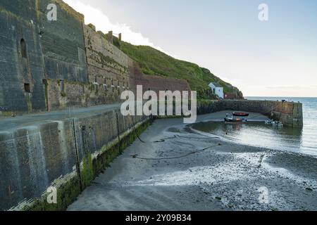 Porthgain, Pembrokeshire, Dyfed, Galles, Regno Unito, 19 maggio 2017: il porto con le vecchie costruzioni di cava e una barca Foto Stock