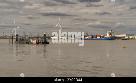 Gravesend, Kent, Inghilterra, Regno Unito, 23 settembre, 2017: vista sul Tamigi con turbine eoliche, una nave da carico e gru portuali sullo sfondo Foto Stock