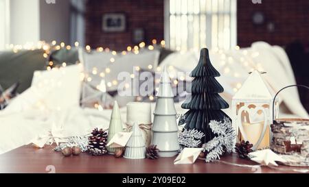 Composizione di Natale o Capodanno con varie decorazioni per la casa, diversi giocattoli simbolici composti e ordinati al tavolo da caffè con sfocato Natale l Foto Stock