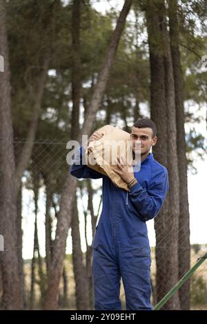 Ritratto di giovani agricoltori e allevatori che portano sacchi di mangime sulle spalle per nutrire i loro animali. concetto di agricoltura, allevamento e anim Foto Stock