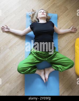 Persone di mezza età o donna matura fare yoga in ambienti interni Foto Stock