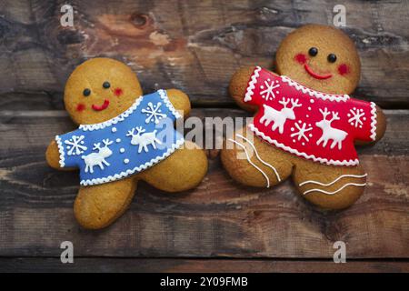 Sorridenti uomini di pan di zenzero natalizio su sfondo di legno Foto Stock