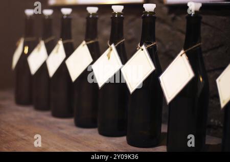 Le bottiglie di vino in fila su di un tavolo di legno Foto Stock