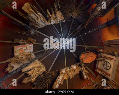 Vista interna (guardando verso l'alto) di un tipo di nativi americani con abiti tradizionali in pelle e contenitori rawhide Foto Stock