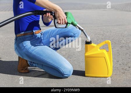 Donna di riempimento può essere di colore giallo con tubi flessibili per benzina all'aperto Foto Stock