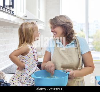 Carino bambina la cottura con sua nonna a casa Foto Stock