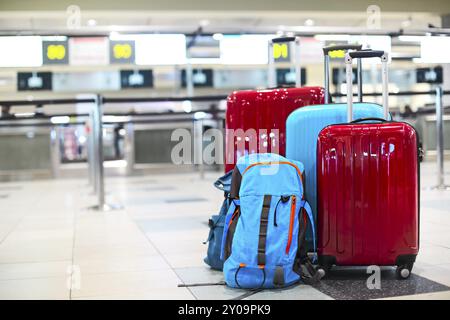 Pila di viaggiatori bagagli nel terminal dell'aeroporto al check in Foto Stock