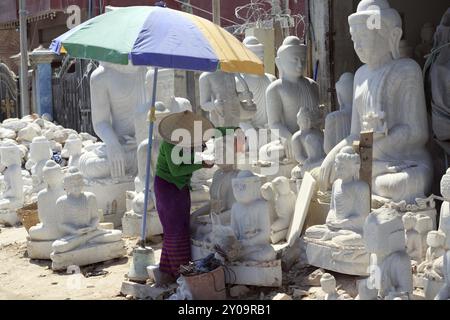 Donna che lucidano una statua del Buddha Foto Stock