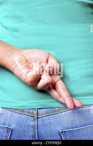 In prossimità delle dita incrociate dietro una donna di back Foto Stock