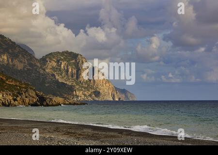 Scogliere rocciose sulla costa con onde spumeggianti e un cielo nuvoloso spettacolare in lontananza, costa meridionale, Lefka Ori, White Mountains, massiccio montuoso, ovest, Foto Stock