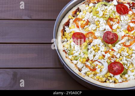 Pizza vegetariana cruda fatta in casa sul tavolo della cucina, pizza cruda Foto Stock