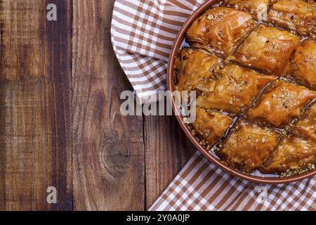 In casa il baklava con noci e sciroppo di miele sul vecchio rustico tavolo in legno Foto Stock