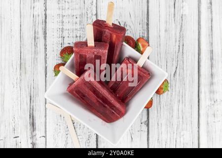 Strawberry Popsicles (foto ravvicinata, messa a fuoco selettiva) su uno sfondo rustico Foto Stock