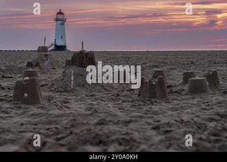 Il Sandcastles On la spiaggia, con serata nuvole e punto di Ayr il faro in background, vicino Talacre, Flintshire, Wales, Regno Unito Foto Stock