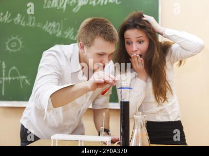 Gli studenti che lavorano nel laboratorio di chimica con formula liquida in aula Foto Stock